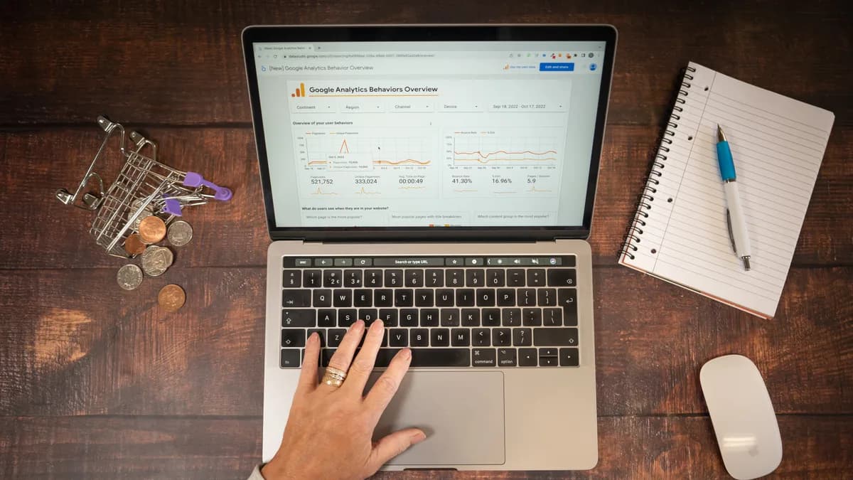 Portátil con analítica ecommerce, carrito de compra y libreta para representar cómo la búsqueda con IA interpreta fichas de producto.